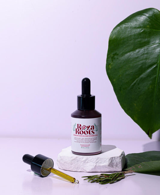 Roza Roots Hair Growth Oil bottle with dropper, natural ingredients display for thicker, fuller hair